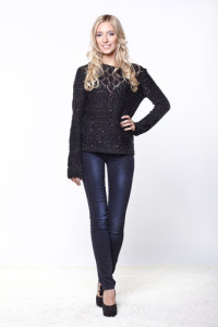 An attractive blonde woman in jeans and a sweater